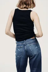 Jean tobillero de cinco bolsillos en denim de algodón, de tiro alto con piernas rectas y detalles de roturas sutiles.