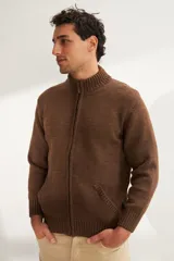 Campera tejida color marrón claro con cierre delantero, cuello alto y bolsillos delanteros. Tejida en 100% lana fina sin teñir.