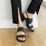 Sandalia de cuero negro con textura, estilo dos tiras anchas y taco cuadrado de madera de 5 cm de altura. Posee una tira fina ajustable en el tobillo.