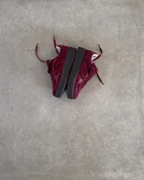 Zapatillas urbanas de cuero vacuno color bordó, con suela alta negra y cordones al tono.