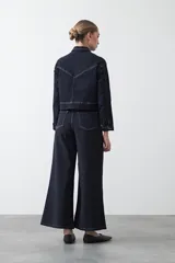 Pantalón de fit flare color beige, confeccionado en cotton spandex, con pespuntes a contratono. Se ajusta suavemente en la cadera y se abre hacia el ruedo.