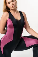 Mono deportivo negro con paneles laterales en magenta y escote con microtul. Espalda abierta con ganchos reforzados en el cuello.