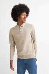Sweater de punto color beige con cuello polo blanco y mangas largas.