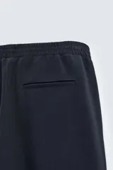 Pantalón relaxed fit color azul marino, confeccionado en tejido fluido con viscosa. Cuenta con cintura elástica ajustable con cordón interior, bolsillos laterales y bolsillos traseros de vivo. Las perneras tienen costura frontal y el bajo es ajustable con cremalleras laterales.