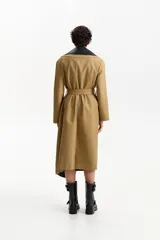 Gabardina larga color camel de silueta recta, con cuello de solapa ancha en contraste de piel sintética negra. Posee mangas largas, bolsillos laterales con solapa y cinturón a juego para ajustar a la cintura.