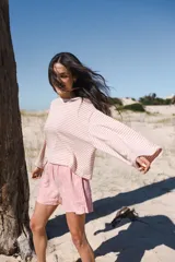 Remera de mangas largas a rayas horizontales verdes y blancas, de corte amplio y cuello redondo.