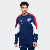 Buzo de cuello redondo azul marino con mangas rojas y paneles blancos en los laterales. Presenta el logo de Umbro bordado en blanco y el escudo del Club Nacional de Football bordado en el pecho. Corte clásico.