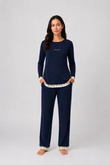 Pijama de dos piezas color azul marino, compuesto por una remera de manga larga con detalle de puntilla en el ruedo y puños, y un pantalón recto a juego con detalle de puntilla en el ruedo.