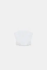 Top corto blanco de escote recto y tirantes finos. Presenta detalles de bordados perforados combinados a tono y un ruedo con volado.