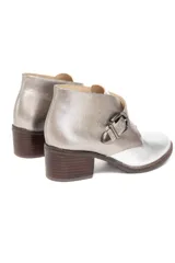 Bota corta de cuero vacuno con acabado metalizado peltre, diseño de solapa cruzada con hebilla metálica lateral y taco cuadrado efecto madera.