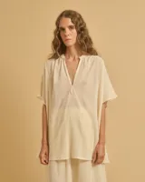 Túnica color crema con mangas anchas, cuerpo acampanado y escote en V.