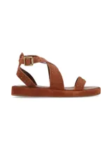 Sandalia plana de gamuza marrón chocolate, con tiras cruzadas decoradas con tachas metálicas doradas y tira ajustable al tobillo con hebilla metálica.