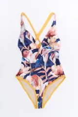 Malla enteriza con estampado floral en tonos azules, rosados y blancos, con breteles cruzados en color amarillo y bordes amarillos en las aberturas de las piernas.