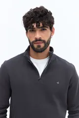 Buzo de algodón color azul marino con medio cierre frontal y cuello alto. Presenta un pequeño logo bordado en el pecho.