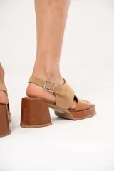 Sandalia de cuero color camel con punta redonda, plataforma de 2 cm y taco cuadrado forrado en cuero de 7 cm. Tiene tira ancha sobre el empeine y pulsera con hebilla.