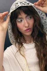 Capucha de encaje negro con diseño de escamas, ajustable y confeccionada en poliamida.