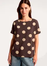 Blusa de manga corta con cuello redondo, confeccionada en tejido ligero con estampado de rayas verticales en tonos azul marino y celeste sobre fondo blanco.