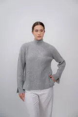 Polera gris de tejido de punto grueso, con cuello alto y mangas largas.