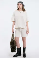 Top de tejido de punto color marrón, con cuello redondo y mangas cortas de corte holgado.