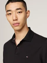 Chomba negra Tommy Hilfiger Sport de corte regular, confeccionada en tejido técnico de piqué de mezcla de algodón elástico, con tecnología Flex, que absorbe la humedad y es antiolor. Tiene cuello de chomba, cartera de dos botones, logo de Tommy Hilfiger Sport en el pecho y detalles distintivos de la marca.