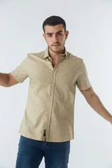 Camisa de hombre Mistral con look lino, de manga corta y corte slim. Presenta un estampado lineal de flores en color azul sobre fondo blanco, cartera abotonada y logo bordado en el pecho.