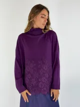 Sweater de punto color violeta con cuello alto y detalle de encaje floral en el ruedo.