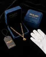 Collar de acero con baño de oro, compuesto por una cadena de eslabones y un dije en forma de pelota de fútbol esmaltada en negro.