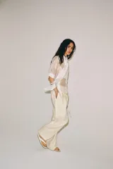 Camisa blanca de tejido semitransparente ZARA Woman Collection, con cuello redondo, manga corta y detalle de pañuelo integrado en el mismo tejido al cuello. Cierre frontal con botones.