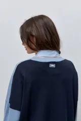 Sweater tejido celeste de calce relajado con cuello redondo, hombros caídos y puños y ruedo acanalados con detalles en tono tostado.