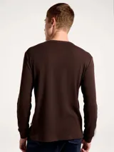 Camiseta térmica de manga larga con cuello redondo, confeccionada en tejido de punto tipo waffle en color beige.