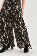 Pantalon de corte amplio y fluido con estampado de cebra en tonos negro y dorado metalizado. Presenta cintura alta y forro interior.