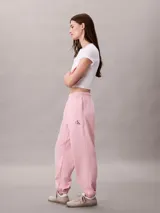 Jogger de felpa Calvin Klein color rosado, de corte tapered con cintura elástica, bolsillos laterales y bajos de canalé. Cuenta con un pequeño monograma estampado en la pierna.
