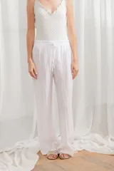 Pantalon de lino de corte ancho y tiro alto, con cintura elástica tipo smock y cordón ajustable.