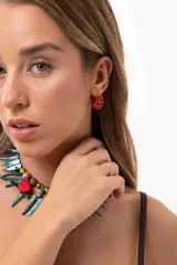 Aro tipo argolla pequeña de acero quirúrgico, decorado con mostacillas rojas entrelazadas alrededor de toda la pieza.