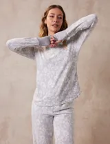 Conjunto de pijama estampado marca René Rofé, compuesto por pantalón largo y remera de mangas largas con puños. El pantalón tiene cintura elastizada con lazo de ajuste.