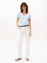 Remera de manga corta color celeste claro, con cuello en V y puños doblados. Presenta un pequeño logo bordado en el pecho.