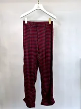 Pantalón largo de tela a cuadros rojos y negros con cintura elastizada.