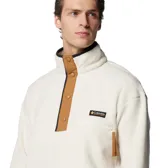 Buzo polar Columbia modelo Helvetia Snap Fleece, de color blanco crema con detalles en color marrón en la solapa de botones y el bolsillo. Presenta cuello alto con cierre de botones a presión, bolsillo frontal con cierre y logo de la marca en el pecho.