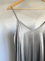 Vestido largo gris de breteles finos y escote en V, confeccionado en tela nacarada.