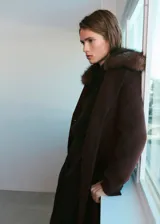 Abrigo largo de corte recto confeccionado en tejido mezcla de lana, con cuello de solapa y detalle de cuello de pelo sintético extraíble. Presenta cierre frontal con botones, mangas largas y dos bolsillos de solapa en la parte delantera.