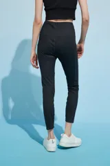 Calza deportiva larga color verde azulado con pretina alta y bolsillos laterales.