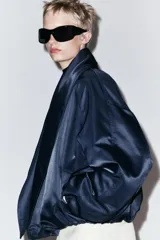 Chaqueta bomber negra ZW Collection con acolchado interior, cuello envolvente de solapa cruzada, mangas largas con puños elásticos y bajo con elástico.