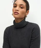 Vestido midi de corte recto y tejido rib, con cuello alto y mangas largas. Presenta un diseño minimalista y ajustado al cuerpo.