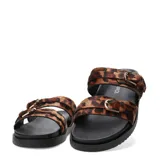 Sandalias planas Miss Carol Brava con diseño tipo slide, doble tira ancha de pelo sintético con estampado animal print de leopardo, hebillas metálicas doradas y suela negra con plataforma baja.