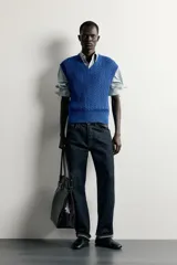 Chaleco de punto trenzado color azul, de corte relaxed fit, con cuello en V y sisas acabadas en rib.