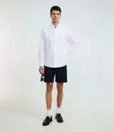 Camisa de manga larga en tejido oxford de algodón color blanco, con cuello tradicional y cierre frontal de botones.