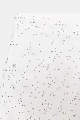 Short de denim blanco, tiro alto, con cinco bolsillos y detalle de strass distribuido por toda la prenda. El bajo es deshilachado.