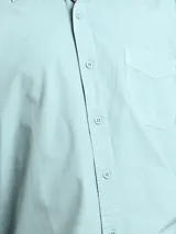 Camisa de manga larga color gris oscuro, confeccionada en algodón, con cuello clásico, cierre frontal con botones, bolsillo de parche en el pecho y corte clásico.