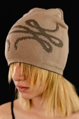 Beanie tejido reversible de algodón, con diseño gráfico abstracto en contraste. Presenta una etiqueta con logo en el borde inferior.