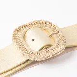 Cinto elástico de color dorado con hebilla redonda forrada en hilo trenzado del mismo tono.